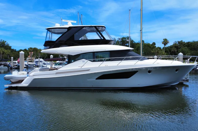 The Image of 2017 Tiara Yachts F53 Flybridge docked in a serene marina setting. - 0