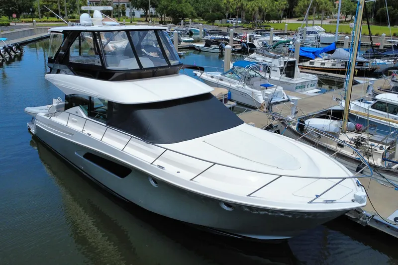 Slide: The Image of 2017 Tiara Yachts F53 Flybridge docked at a marina, surrounded by other boats. - 1