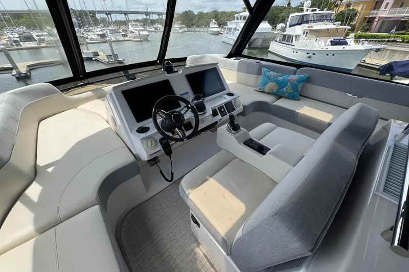 Slide: The Image of Luxurious 2017 Tiara Yachts F53 Flybridge helm with modern controls and marina view. - 10