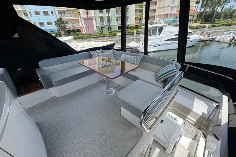 Slide: The Image of Luxurious 2017 Tiara Yachts F53 Flybridge interior with elegant seating and marina view. - 16
