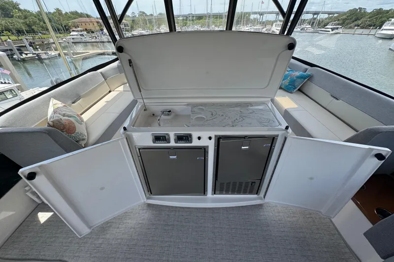 Slide: The Image of 2017 Tiara Yachts F53 Flybridge interior with kitchenette and seating area. - 17