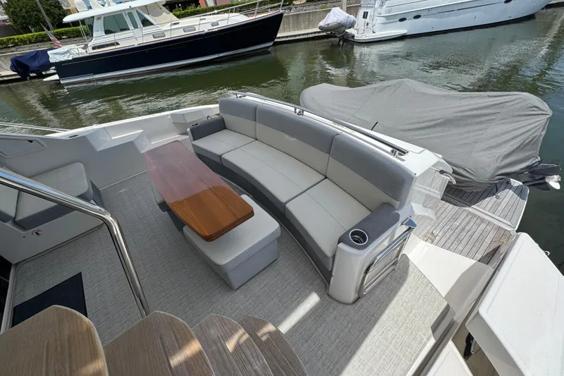 Slide: The Image of 2017 Tiara Yachts F53 Flybridge with elegant seating and wooden table on deck. - 24