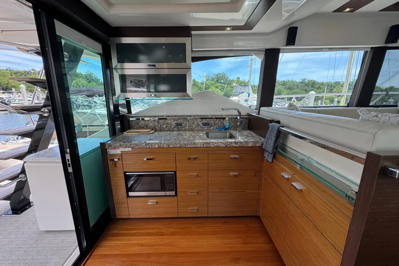 Slide: The Image of Luxurious 2017 Tiara Yachts F53 Flybridge kitchen with modern amenities and scenic marina view. - 32