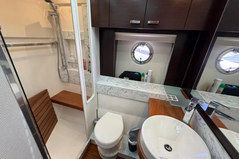 Slide: The Image of Luxurious bathroom in 2017 Tiara Yachts F53 Flybridge with modern fixtures and porthole window. - 43