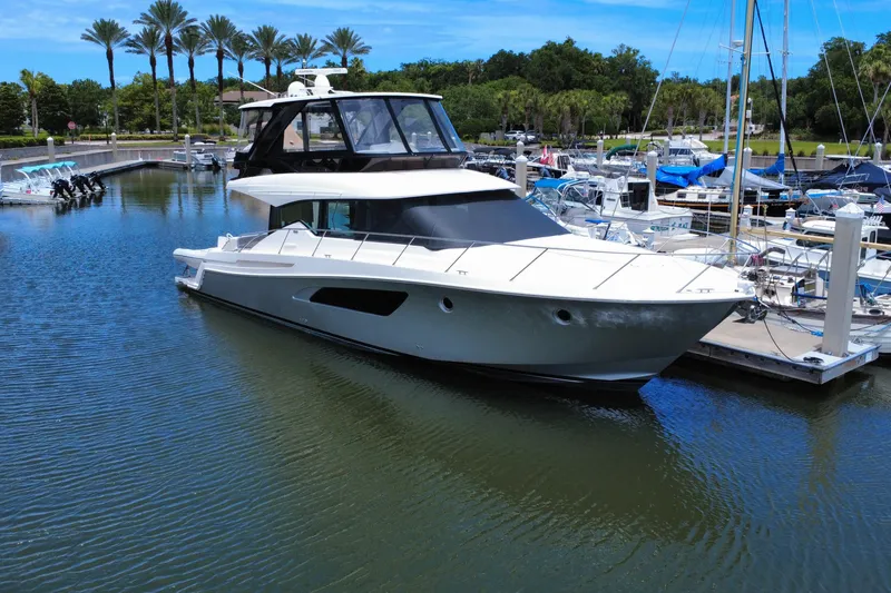 Slide: The Image of 2017 Tiara Yachts F53 Flybridge docked in a marina with palm trees. - 5