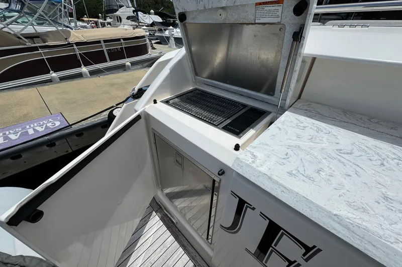 Slide: The Image of Outdoor kitchen on 2017 Tiara Yachts F53 Flybridge, featuring grill and storage. - 57