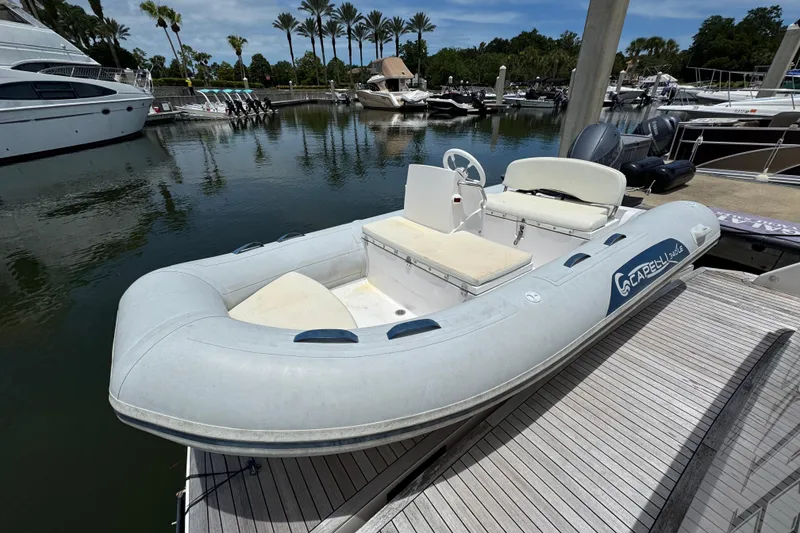Slide: The Image of Inflatable boat docked near Tiara Yachts F53 Flybridge, 2017 model, in a marina setting. - 59
