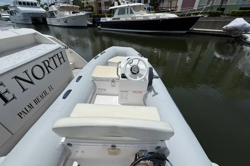 Slide: The Image of Inflatable boat docked near Tiara Yachts F53 Flybridge, 2017 model, in a marina setting. - 61