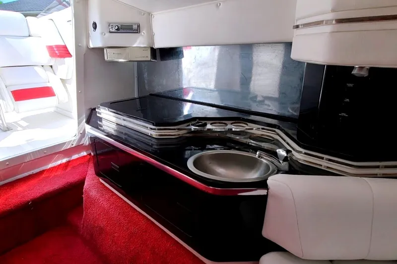 Slide: The Image of Interior of a 1995 Fountain 42 Lightning boat with sleek kitchenette and red carpet. - 14