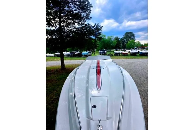 Slide: The Image of 1995 Fountain 42 Lightning boat with red stripe, parked outdoors under cloudy sky. - 5