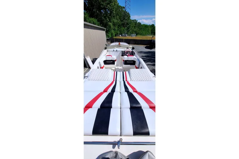 Slide: The Image of 1995 Fountain 42 Lightning boat with striped upholstery, parked outdoors. - 7