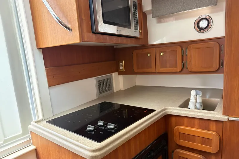 Slide: The Image of 2008 Stamas 370 Express yacht kitchen with wooden cabinets, stove, and microwave. - 5
