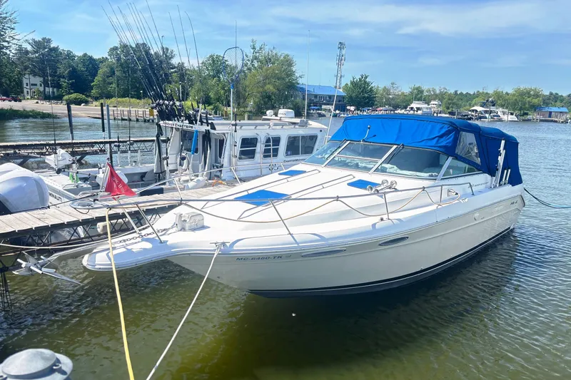 Slide: The Image of 1992 Sea Ray 300 Weekender boat docked at a marina with blue canopy. - 1