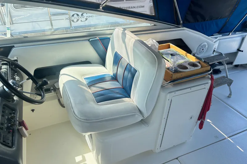 Slide: The Image of Interior of a 1992 Sea Ray 300 Weekender boat with steering wheel and seating. - 13