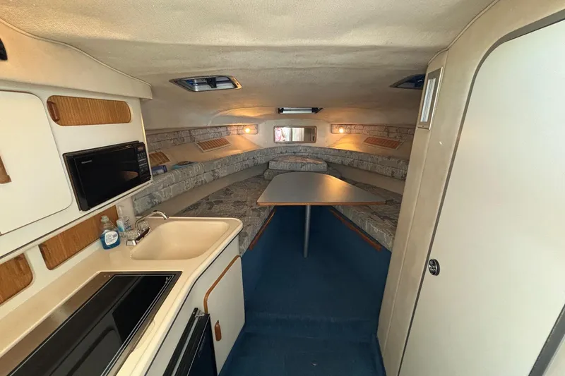 Slide: The Image of 1992 Sea Ray 300 Weekender cabin interior with kitchenette and seating area. - 15