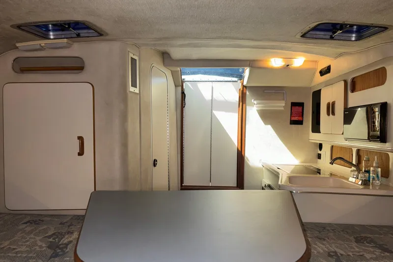 Slide: The Image of Interior of a 1992 Sea Ray 300 Weekender boat, featuring a compact kitchenette. - 16