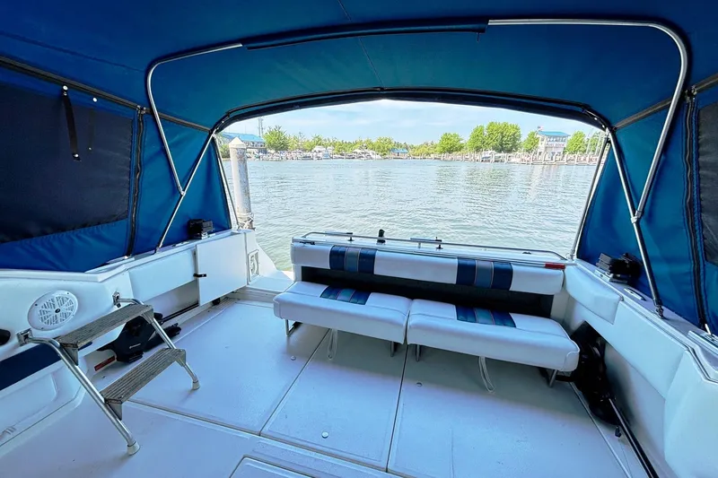 Slide: The Image of 1992 Sea Ray 300 Weekender boat interior with blue canopy and waterfront view. - 9
