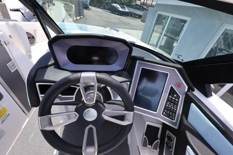 Slide: The Image of 2023 MasterCraft X24 boat dashboard with steering wheel and control panel. - 18