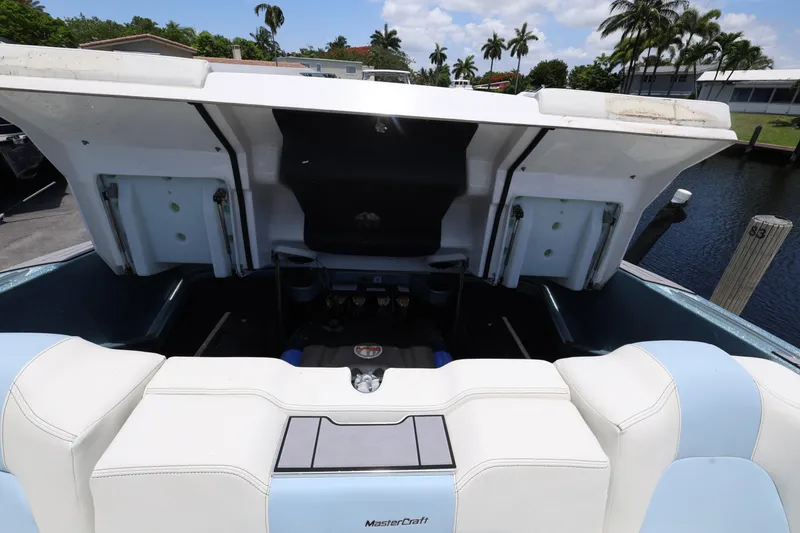 Slide: The Image of 2023 MasterCraft X24 boat engine compartment with open hatch, dockside view. - 28