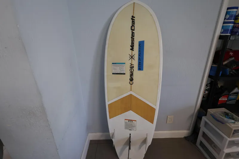 Slide: The Image of 2023 MasterCraft X24 surfboard by Connelly, leaning against a wall in a garage. - 30