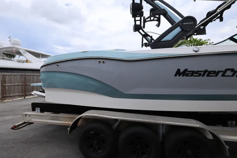Slide: The Image of 2023 MasterCraft X24 boat on trailer, side view with sleek design and modern features. - 6