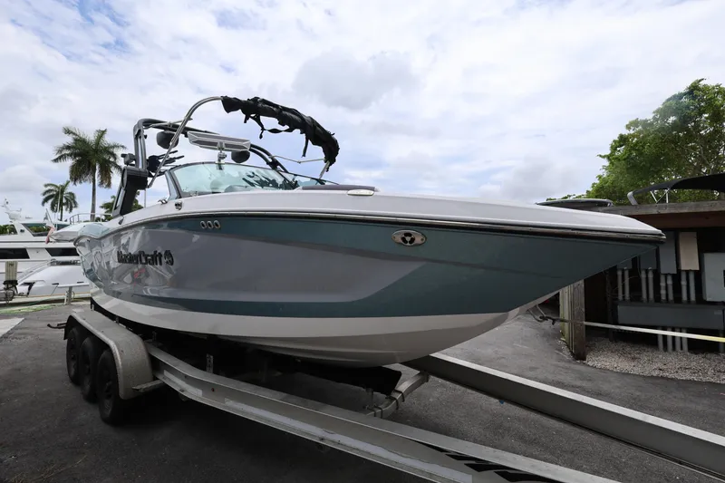 Slide: The Image of 2023 MasterCraft X24 boat on trailer, parked outdoors under cloudy sky. - 7