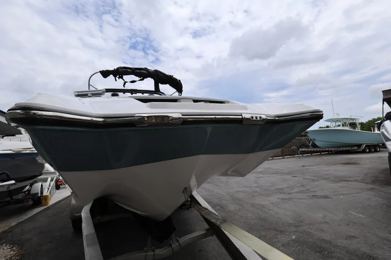 Slide: The Image of 2023 MasterCraft X24 boat on trailer under cloudy sky. - 8