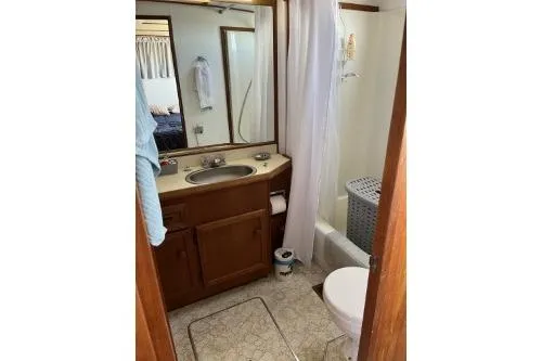 Slide: The Image of 1983 Uniflite Cabin Cruiser bathroom with sink, toilet, and shower. - 13