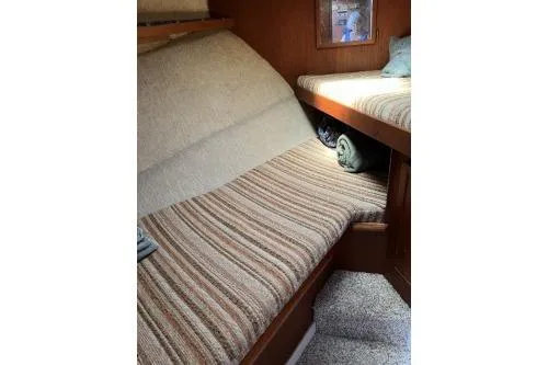 Slide: The Image of 1983 Uniflite Cabin Cruiser interior with striped upholstery and cozy sleeping area. - 15