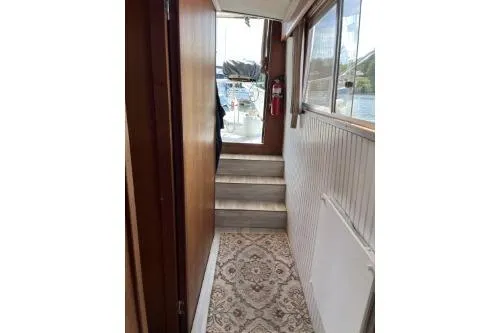 Slide: The Image of 1983 Uniflite Cabin Cruiser interior hallway with patterned flooring and wooden paneling. - 16