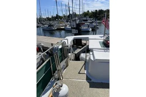 Slide: The Image of 1983 Uniflite Cabin Cruiser docked at a marina with sailboats in the background. - 17