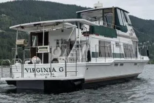 Slide: The Image of 1983 Uniflite Cabin Cruiser on a scenic lake with forested hills in the background. - 2