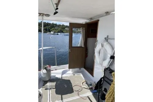 Slide: The Image of 1983 Uniflite Cabin Cruiser interior with open door, life preserver, and scenic water view. - 4