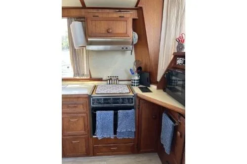 Slide: The Image of 1983 Uniflite Cabin Cruiser kitchen with wooden cabinets and modern appliances. - 9