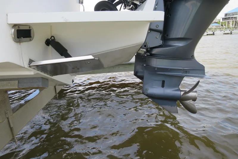 Slide: The Image of 2016 Regulator 28 boat with outboard motor and trim tab in water. - 10