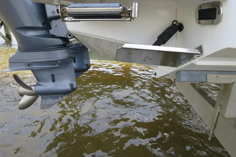 Slide: The Image of 2016 Regulator 28 boat with outboard motor and trim tab over water. - 11
