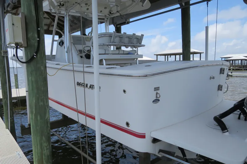 Slide: The Image of 2016 Regulator 28 boat docked, featuring a sleek white design with red accents. - 2