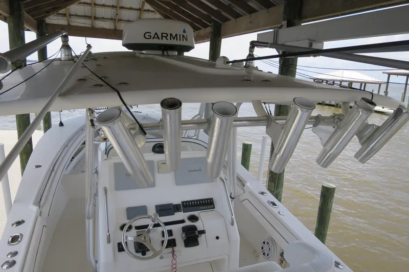 Slide: The Image of 2016 Regulator 28 boat with Garmin equipment, docked under a wooden shelter. - 8