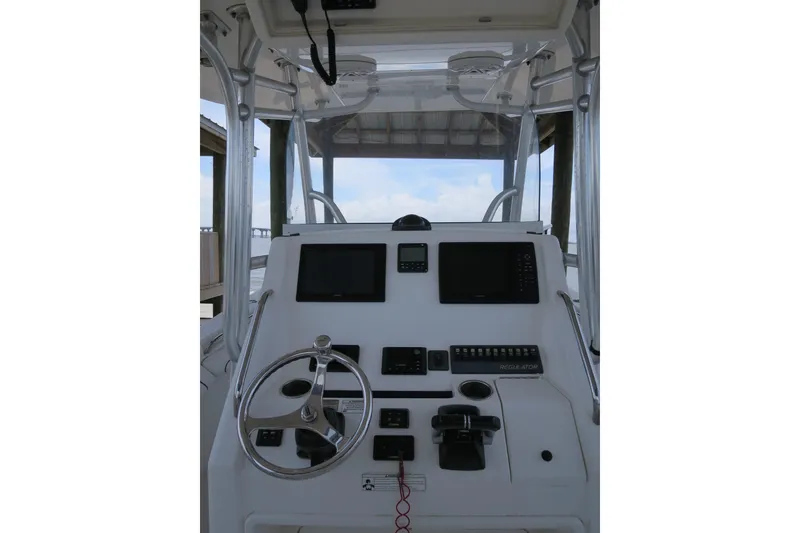 Slide: The Image of 2016 Regulator 28 boat dashboard with steering wheel and electronic controls. - 9