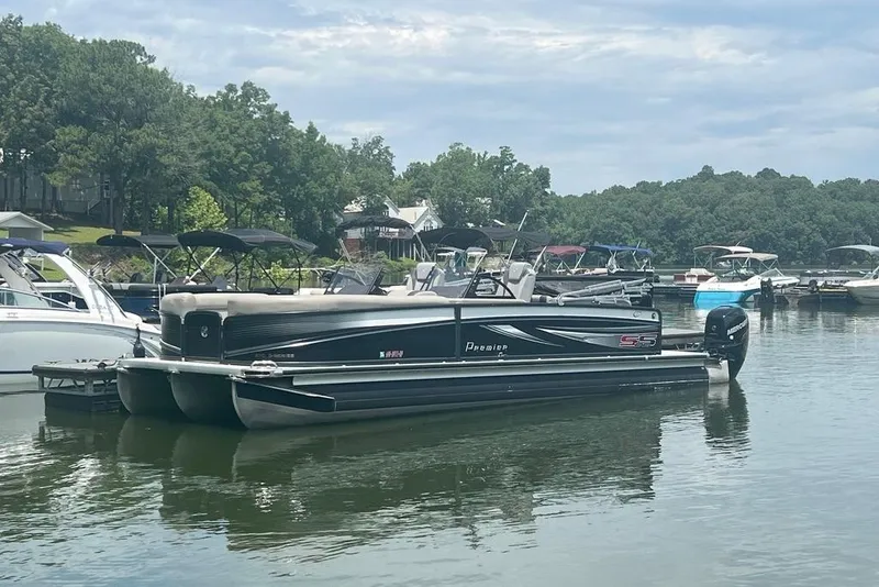 The Image of 2017 Premier 270 Super Sport pontoon boat docked on a calm lake. - 1