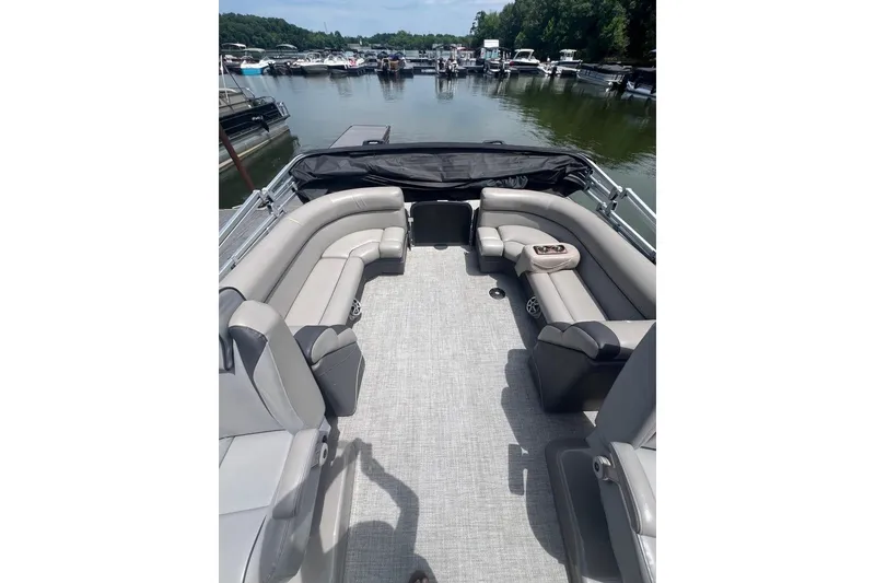 Slide: The Image of 2017 Premier 270 Super Sport pontoon boat with spacious seating, docked on a calm lake. - 7