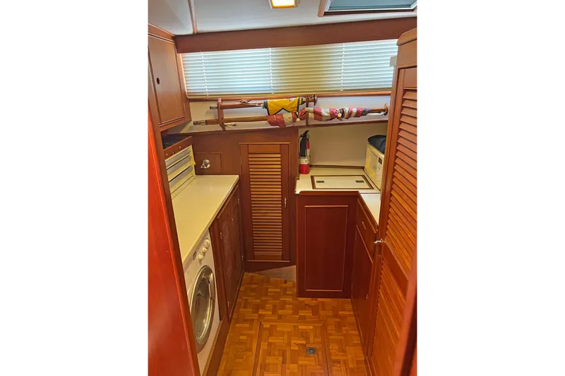 Slide: The Image of Laundry area inside 1991 Grand Banks 42 Motoryacht with wooden cabinetry and appliances. - 14