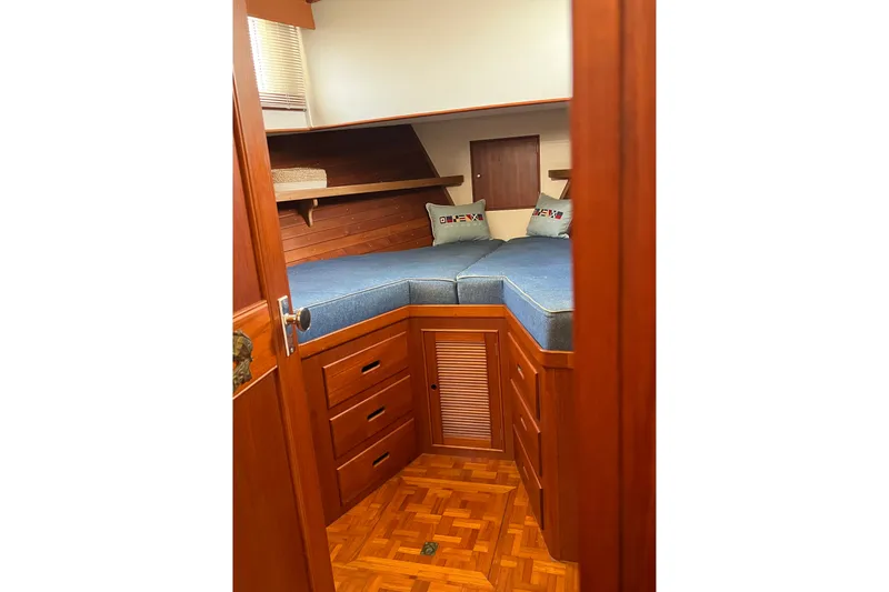 Slide: The Image of Cozy cabin interior of 1991 Grand Banks 42 Motoryacht with wooden furnishings and blue bedding. - 15