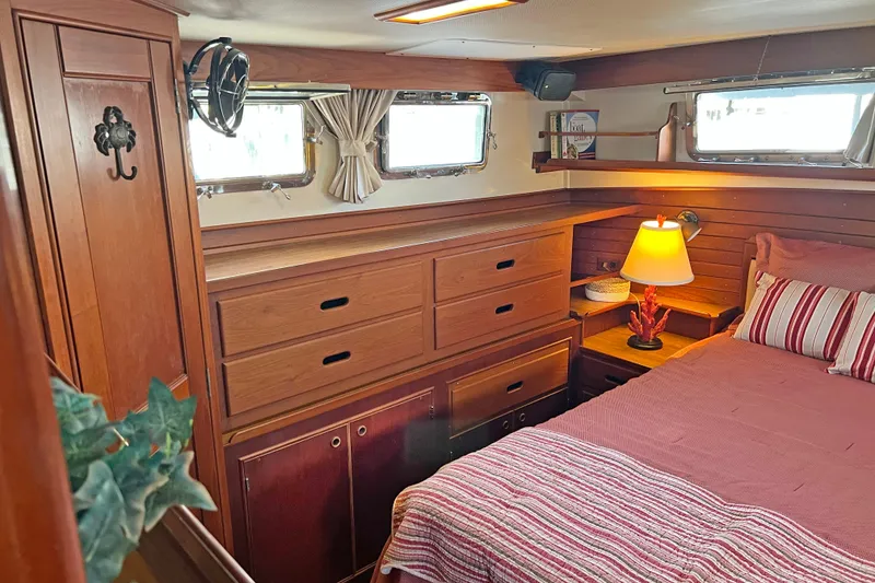Slide: The Image of Cozy cabin interior of 1991 Grand Banks 42 Motoryacht with wood furnishings and striped bedding. - 20