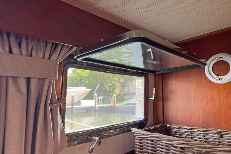Slide: The Image of Interior view of a 1991 Grand Banks 42 Motoryacht window with curtain and wicker basket. - 23