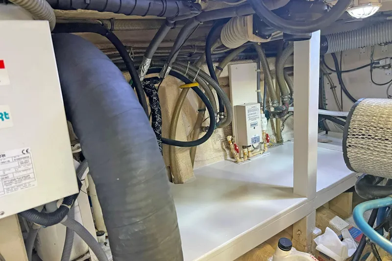 Slide: The Image of Engine room of 1991 Grand Banks 42 Motoryacht with visible hoses and equipment. - 28