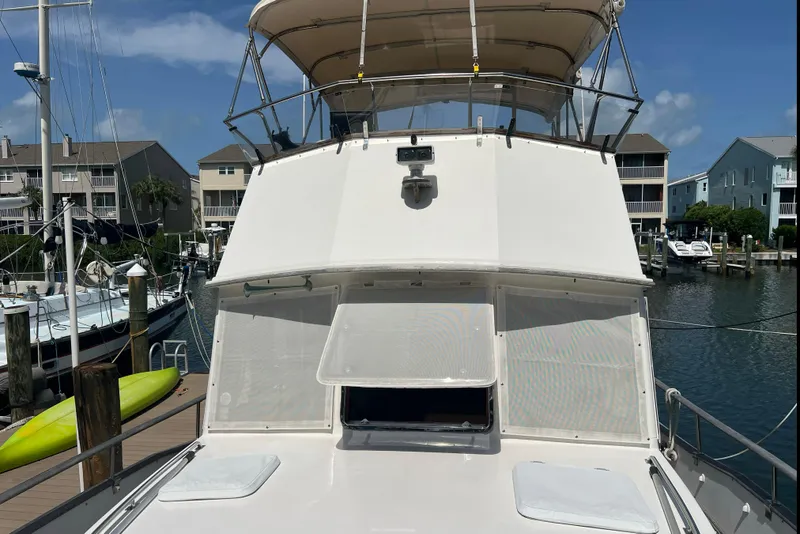 Slide: The Image of 1991 Grand Banks 42 Motoryacht docked at marina, showcasing upper deck and cabin. - 34