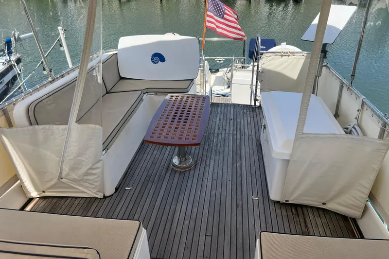 Slide: The Image of Grand Banks 42 Motoryacht 1991 aft deck with seating, table, and American flag. - 37