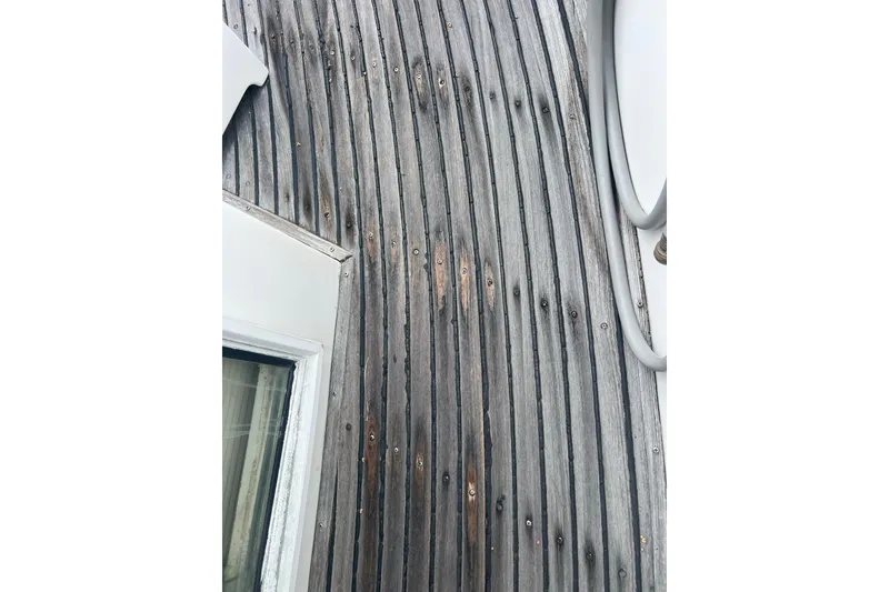 Slide: The Image of Weathered teak deck of 1991 Grand Banks 42 Motoryacht, showing aged wood texture. - 40