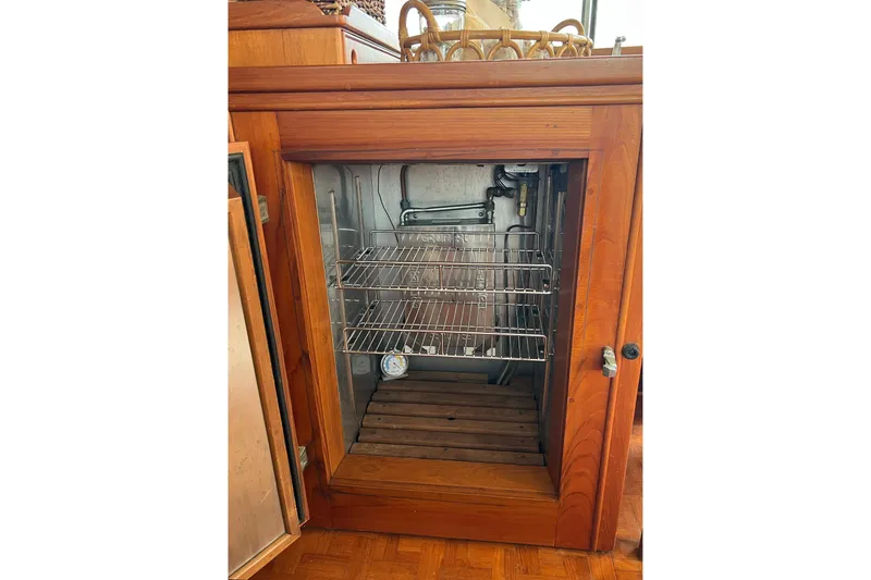 Slide: The Image of Wooden cabinet with open door revealing metal shelves inside a 1991 Grand Banks 42 Motoryacht. - 9